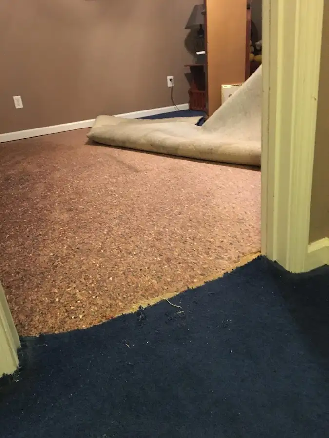 Carpet pad removal revealing water damage during Water Mitigation Services in Fayetteville